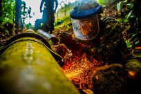 A U.S. Marine begins cutting sections of a broken water pipe in Trujillo, Honduras, Sept. 19, 2018.