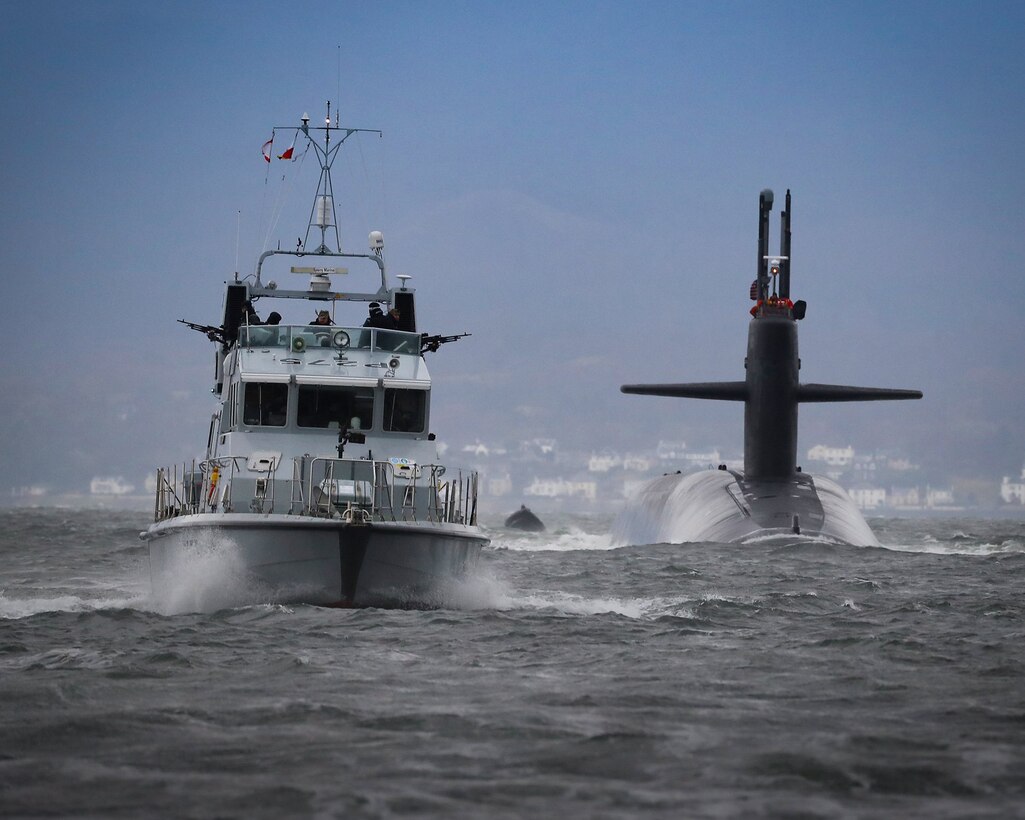 A submarine and boat drive past one another.