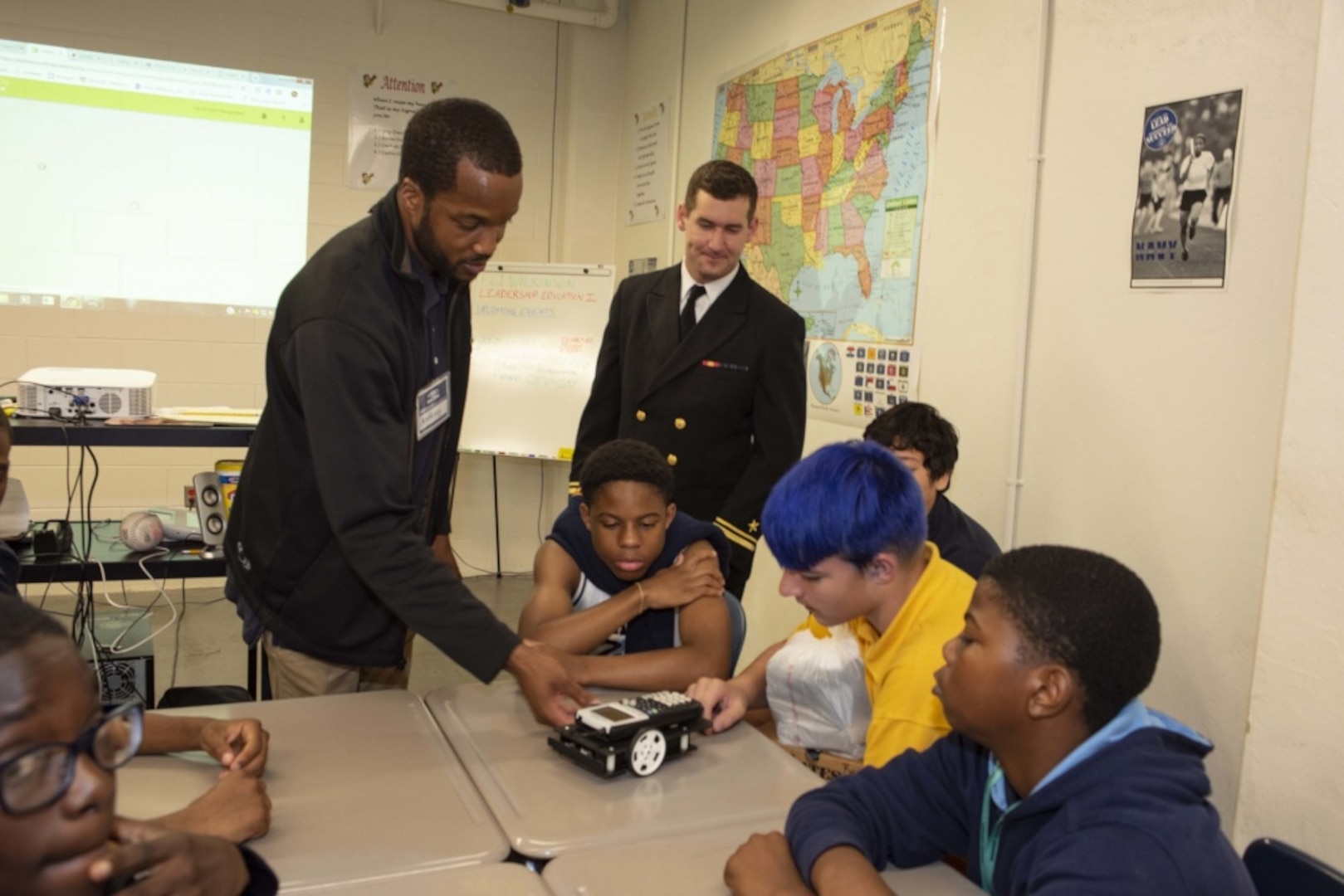 Sailors assigned to the Ohio-class ballistic missile submarine USS Maryland (SSBN 738) and engineers from Naval Surface Warfare Center, Carderock Division demonstrate calculator-controlled robots to Navy Junior Reserve Officers Training Corps students at Mergenthaler Vocational Technical Senior High School as part of Maryland Fleet Week and Air Show Baltimore. Calculator-controlled robots are part of Carderock's Division's science, technology, engineering and math outreach program and teaches students to program the robots to carry out a variety of tasks. MDFWASB is Baltimore's celebration of the sea services and provides an opportunity for the citizens of Maryland and the city of Baltimore to meet Sailors, Marines and Coast Guardsmen, as well as see firsthand the latest capabilities of today's maritime services. (U.S. Navy photo by Martin Sheehan/Released)