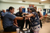 Robert Kometshcer instructs a teacher as she practices using a tourniquet on a paramedic at Bolden Elementary
School on Laurel Bay, Oct. 9. In observance of National Fire Prevention Week, the MCAS Beaufort Fire and
Emergency Services visited Laurel Bay Schools. Later that day, they taught teachers how to utilize a trauma medical
kit. Kometscher is paramedic with MCAS Beaufort Fire and Emergency Services.