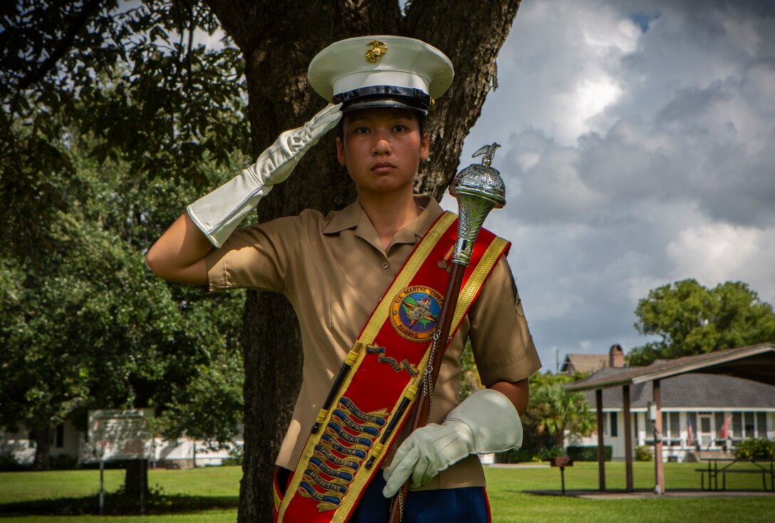 Sgt. Maria Dewey, drum major with the Marine Forces Reserve Band, salutes during the national anthem at the Algiers Festival 2018 in Federal City, New Orleans, Oct. 6, 2018. The band performed to show their support towards the New Orleans community and kicked off the Algiers Festival 2018. (U.S. Marine Corps photo by Cpl, Andy O. Martinez)