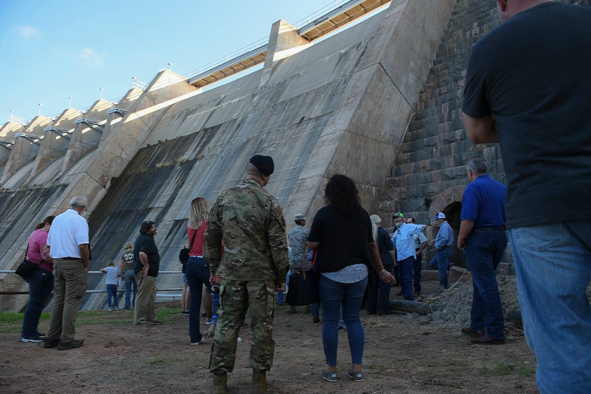 Members of the 97th Air Mobility Wing look at Lake Altus-Lugert Dam while listening to Tom Buchanan, irrigation district manager, during the tour of the dam, Oct. 5, 2018, in Lugert, Okla.