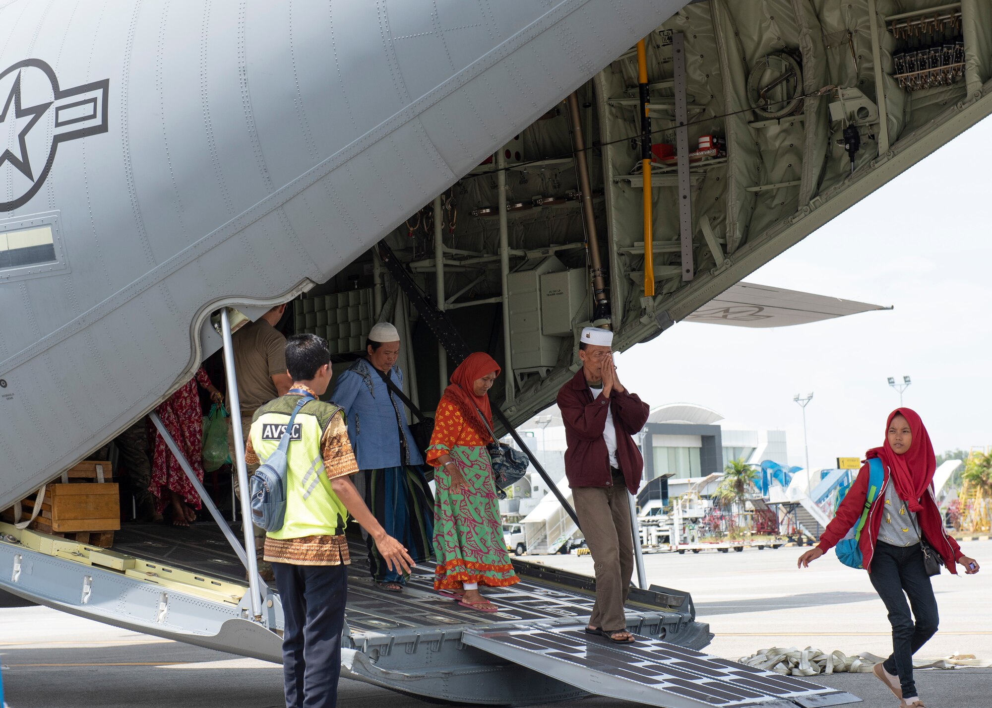 An Indonesian man raises his hands as a sign of thank you after landing at the airport in Balikpapan, Indonesia Oct. 9, 2018.