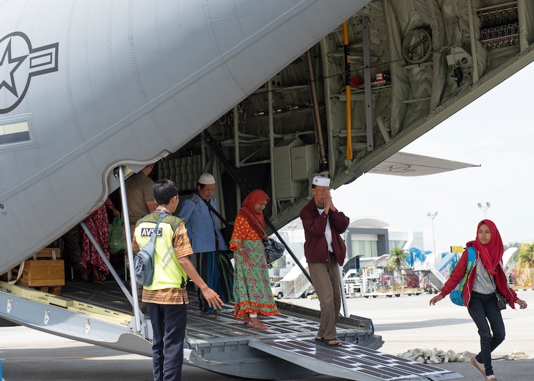 An Indonesian man raises his hands as a sign of thank you after landing at the airport in Balikpapan, Indonesia Oct. 9, 2018.