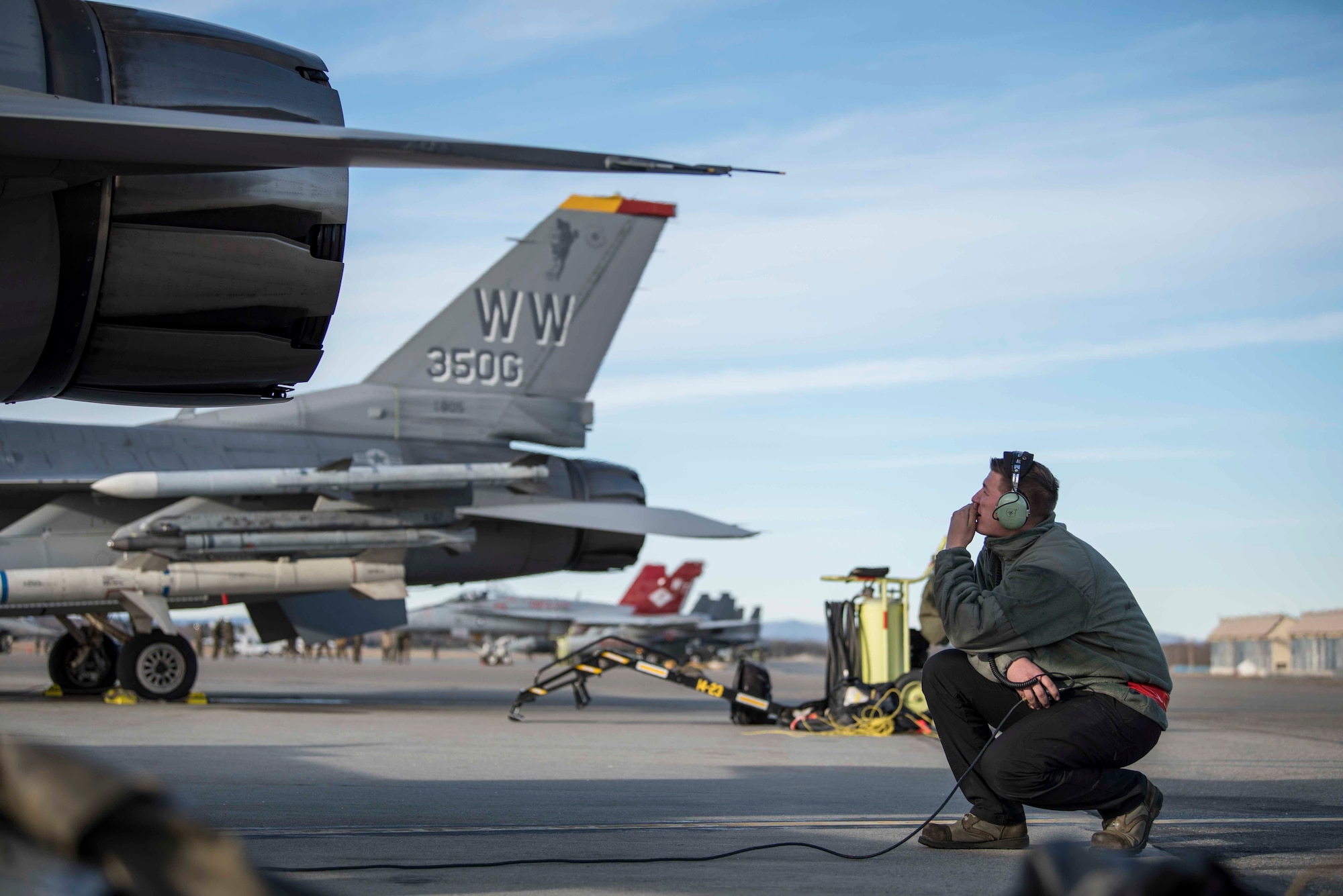 U.S. Air Force Airman 1st Class Kelsie Walls, a 13th Aircraft Maintenance Unit crew chief, communicates over a headset with a pilot prior to take-off during exercise Red Flag-Alaska 19-1, at Eielson Air Force Base, Alaska, Oct. 9, 2018. Maintainers repair jets alongside joint and multilateral partners from around the world affording them opportunities to exchange tactics, operations techniques and procedures which improves international interoperability. (U.S. Air Force photo by Airman 1st Class Collette Brooks)