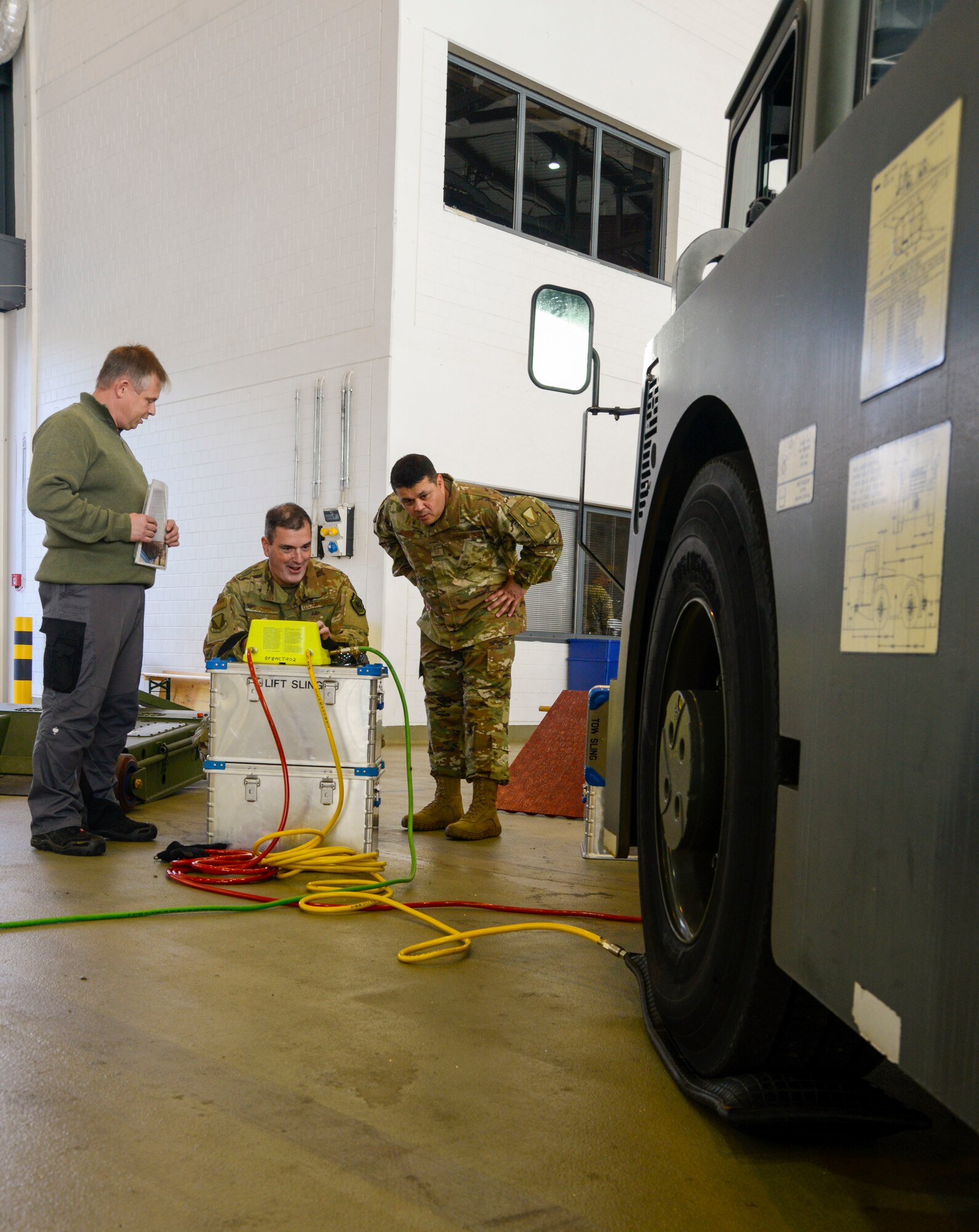 U.S. Air Force Brig. Gen. Mark R. August (center), 86th Airlift Wing commander, and Chief Master Sgt. Ernesto J. Rendon Jr., 86th AW command chief, test some of the new tools the 86th Maintenance Squadron uses during an immersion tour of the 86th Maintenance Group on Ramstein Air Base, Germany, Oct. 9, 2018. The command team learned that many of the new tools not only make the job easier but also make it safer for Airmen. (U.S. Air Force photo by Staff Sgt. Timothy Moore)