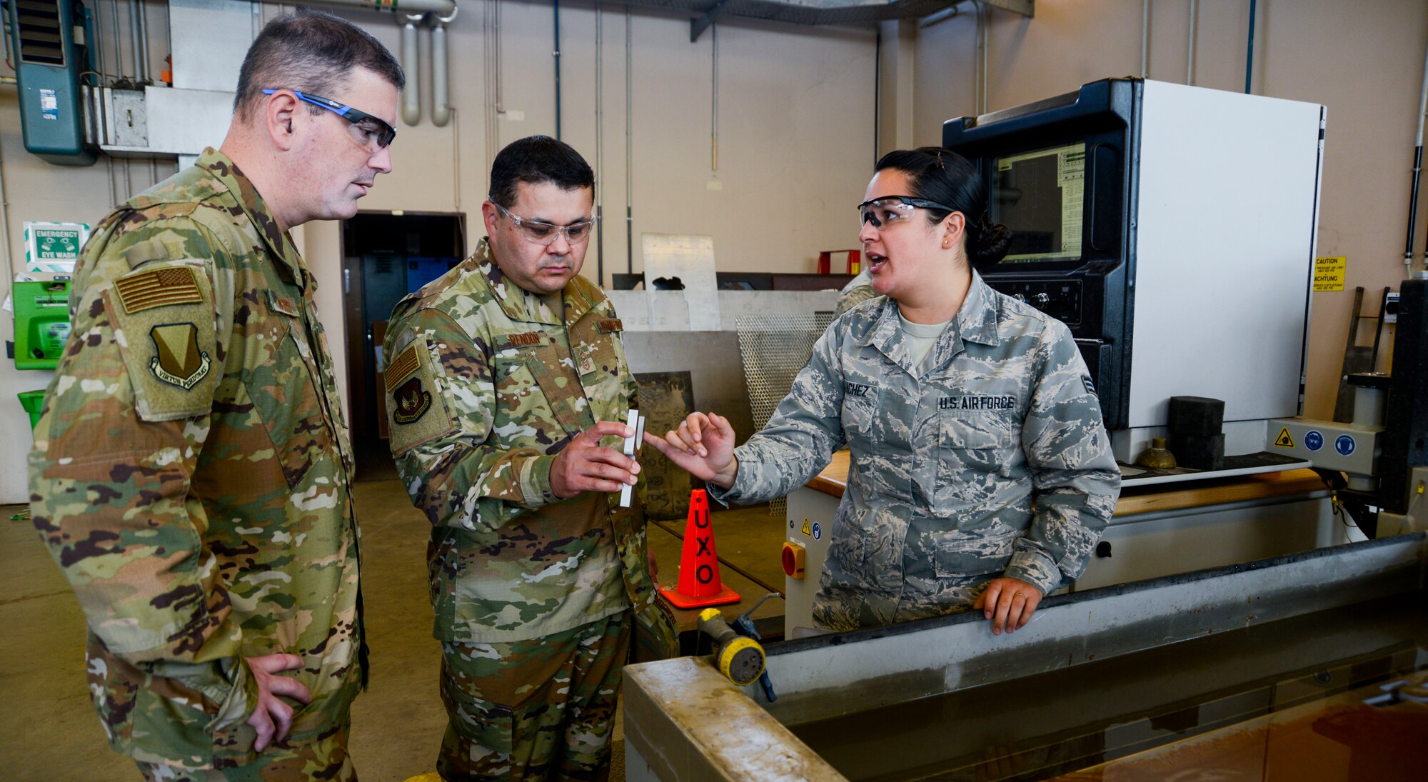 U.S. Air Force Brig. Gen. Mark R. August, 86th Airlift Wing commander, and Chief Master Sgt. Ernesto J. Rendon Jr., 86th AW command chief, view an item the 86th Maintenance Squadron Metals Technology Flight created using a water jet cutting machine during an immersion tour of the 86th Maintenance Group on Ramstein Air Base, Germany, Oct. 9, 2018. The command team used the immersion as a way to get a better understanding of the 86th MXG’s capabilities as well as a way for Airmen to ask questions directly to the wing leaders. (U.S. Air Force photo by Staff Sgt. Timothy Moore)