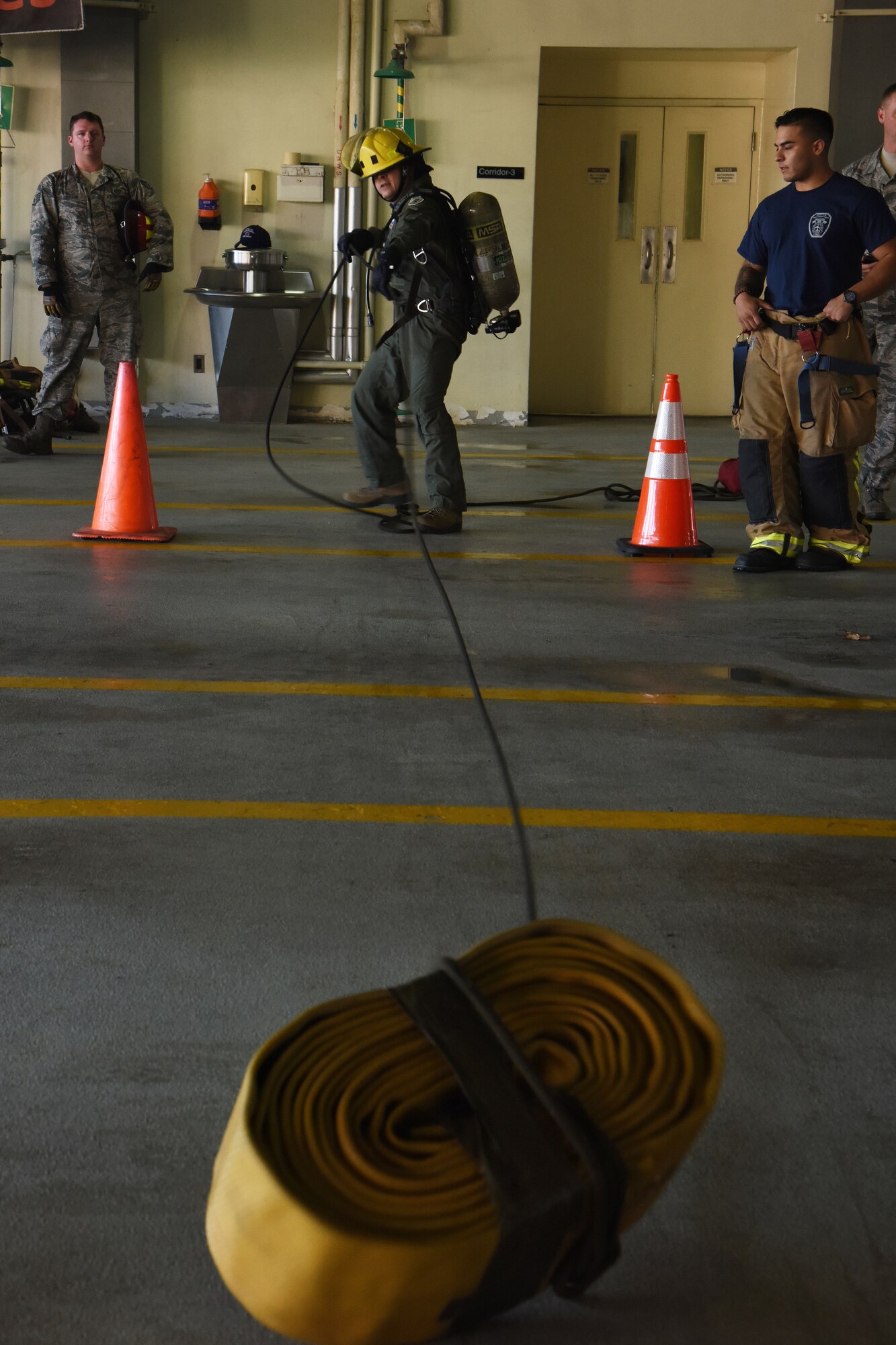 U.S. Air Force Col. Jesse Friedel, 51st Fighter Wing vice commander, pulls in a fire hose during the Eagles and Commanders versus Chiefs and Shirts Fire Muster at Osan Air Base, Republic of Korea, Oct. 12, 2018. The friendly competition between higher officer and enlisted leaders was part of Fire Prevention Week, held 9 through 13 Oct., and gave everyone a chance to see what firefighters go through when training and rescuing individuals from fires. (U.S. Air Force photo by Tech. Sgt. Ashley Tyler)
