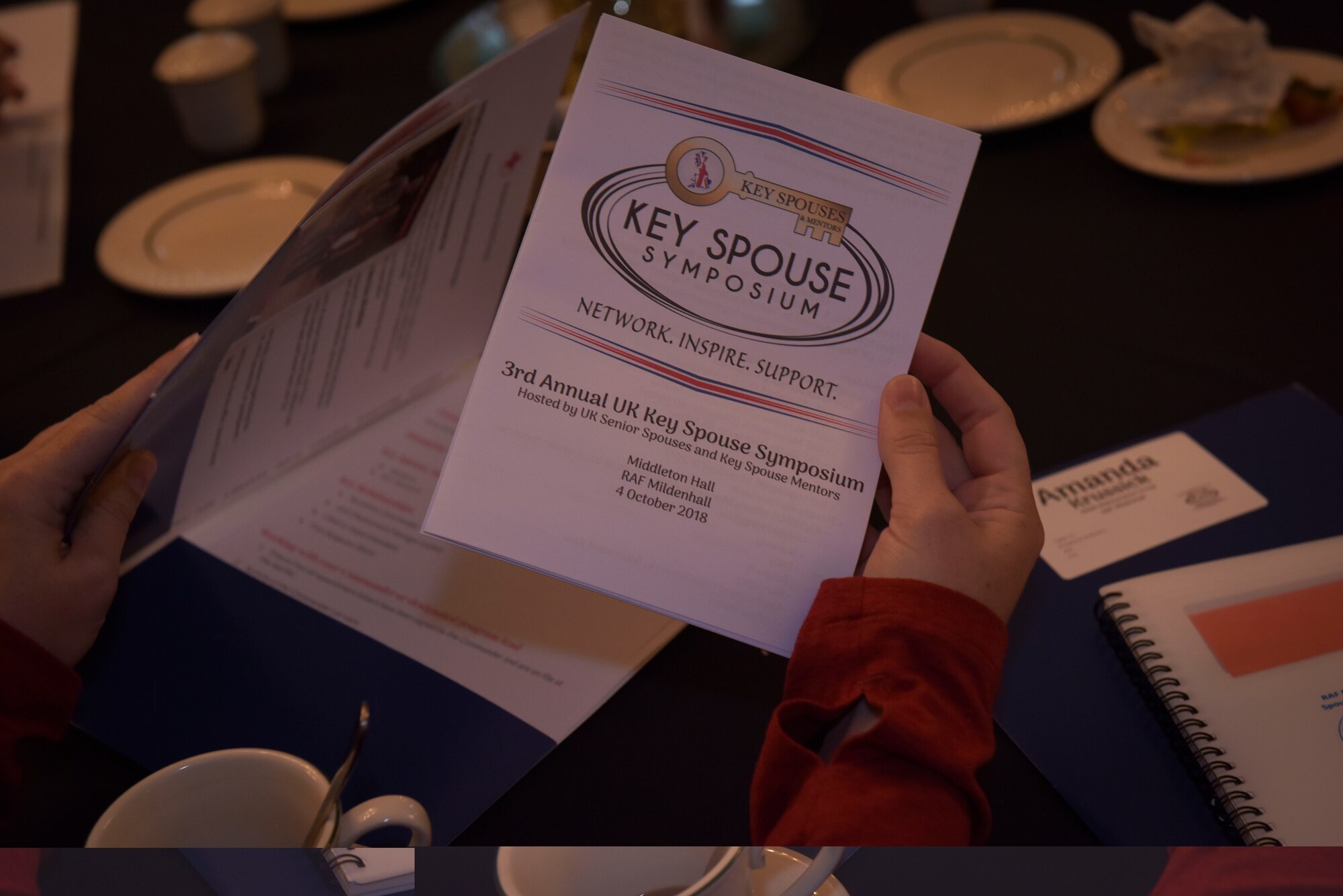 Leah Weme, 100th Maintenance Squadron Key Spouse reads over a Key Spouse Symposium pamphlet at RAF Mildenhall, England, Oct. 4, 2018. The Key Spouses organization is an opportunity for leadership and spouses to bridge the gap between dependents and leadership, as well Airmen as. (U.S. Air Force photo by Airman 1st Class Alexandria Lee)