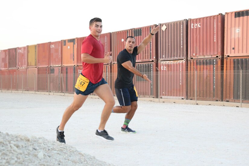 U.S. Army Capt. Filiberto Pacheco (left) and Capt. Evan Cochrane (right) of Area Support Group-Qatar share a thumbs-up and a funny pose during the Army Ten-Miler at Camp As-Sayliyah, Qatar, October 7, 2018.  Many participants in the event ran with a battle buddy in order to motivate and push each other.