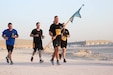 U.S. Army Soldiers from 12th Missile Defense Battery carry their unit guidon at the Army Ten-Miler at Camp As-Sayliyah, Qatar, October 7, 2018.  Unit pride and team comradery were apparent themes throughout the race.