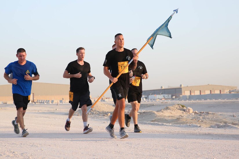 U.S. Army Soldiers from 12th Missile Defense Battery carry their unit guidon at the Army Ten-Miler at Camp As-Sayliyah, Qatar, October 7, 2018.  Unit pride and team comradery were apparent themes throughout the race.