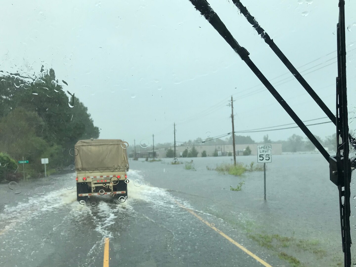 Virginia National Guard Soldiers assigned to the Virginia Beach-based 1173rd Transportation Company drive through high water to deliver supplies to shelters Sept. 17, 2018, in North Carolina.