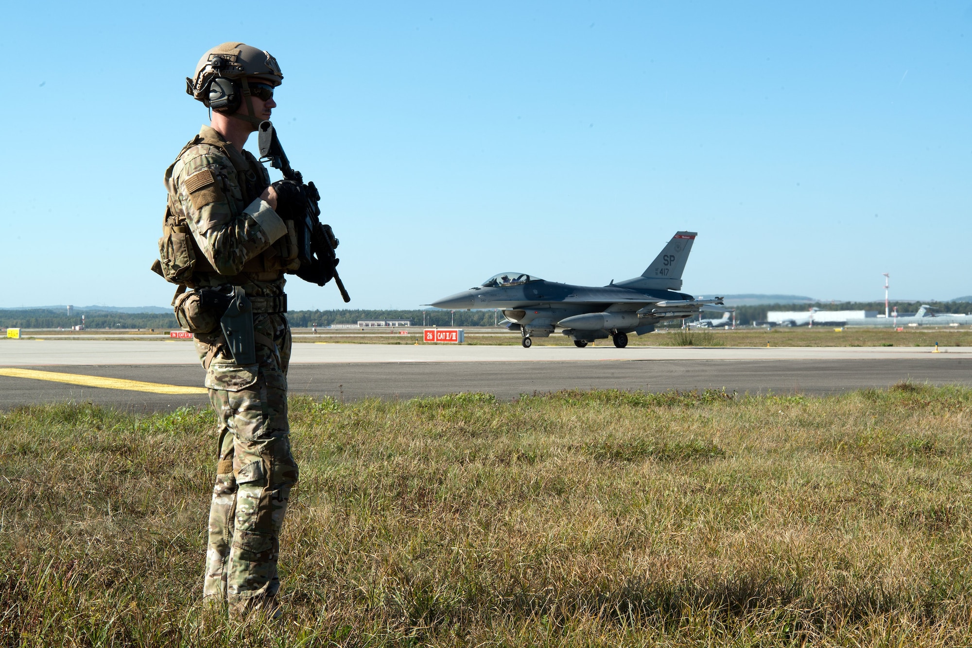 U.S. Air Force Staff Sgt. Dwight Stalter, 435th Security Forces Squadron team leader, stands guard while an F-16 Fighting Falcon pilot waits for his aircraft to be refueled on Ramstein Air Base, Germany, Oct. 4, 2018. Members of the 435th SFS participated in Temperate Ace, a proof-of-concept exercise led by the 435th Air Ground Operations Wing, demonstrating strike force capabilities. (U.S. Air Force Photo by Airman 1st Class Noah D. Coger)