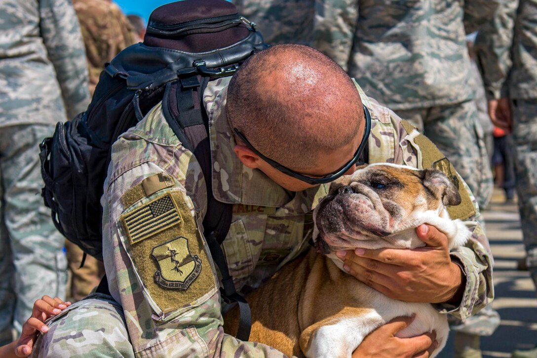 Master Sgt. David Gonzalez, 1st Maintenance Squadron production superintendent, hugs his dog, Roxy, at Joint Base Langley-Eustis, Va., Oct. 9, 2018. The 94th Expeditionary Fighter Squadron flew defensive counter air missions to protect coalition ground forces operating within Syria. (U.S. Air Force photo by Airman 1st Class Monica Roybal)