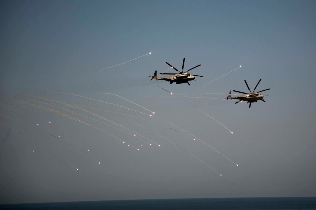 ARABIAN SEA-Two CH-53E Super Stallion Helicopters with Marine Medium Tiltrotor Squadron 166 Reinforced, 13th Marine Expeditionary Unit, launch flares during a training exercise, Oct. 7, 2018. The Essex is the flagship for the Essex Amphibious Ready Group and, with the embarked 13th MEU, is deployed to the U.S. Fifth Fleet area of operations in support of naval operations to ensure maritime stability and security in the Central Region, connecting the Mediterranean and the Pacific through the western Indian Ocean and three strategic choke points.