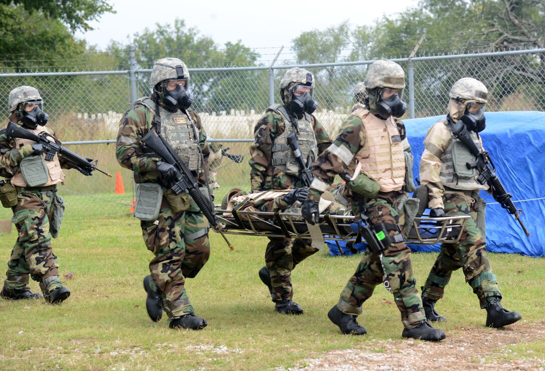 A team participating in the CBRNE exercise carry an injured dummy on a litter to a checkpoint after administering self-aid buddy care. Knowing how to correctly assess injuries, whether critical or fatal, and then help the wounded victim without creating more harm, is an important component during these kinds of exercises.