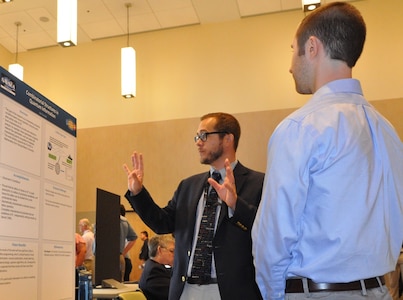 IMAGE: KING GEORGE, Va. (Sept. 25, 2018) – Principal investigator Jake Farinholt briefs a visitor at the Naval Surface Warfare Center Dahlgren Division (NSWCDD) In-house Laboratory Independent Research (ILIR) and Independent Applied Research (IAR) End of Year Review at the University of Mary Washington Dahlgren Campus. Farinholt -- an NSWCDD scientist and expert in quantum computing and quantum cryptography -- explained his ILIR project, "Combinatorial Structures in Quantum Information" to Navy technical managers, engineers, and scientists as well as representatives from academia, industry, transition partners, and other key stakeholders. Funded by the Office of Naval Research, the ILIR and IAR program fosters fundamental and applied research at the Navy Warfare Centers to counter emerging threats by connecting technological needs with current and emerging capabilities.