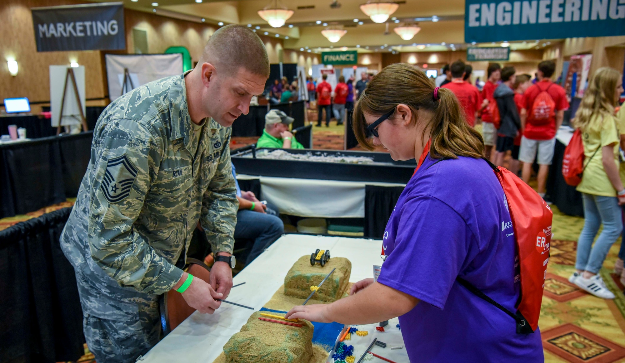 Senior Master Sgt. Thomas Ryan, 14th Civil Engineer Squadron superintendent, works on building a bridge with a student Oct. 2, 2018, during the Imagine the Possibilities Career Expo at the BancorpSouth Arena in Tupelo, Mississippi. More than 120 Airmen from Columbus AFB, Mississippi, spent several days showing more than 7,000 eighth-grade students, from northeast Mississippi counties, some of the vast career opportunities the Air Force offers. (U.S. Air Force photo by Tech. Sgt. Christopher Gross)