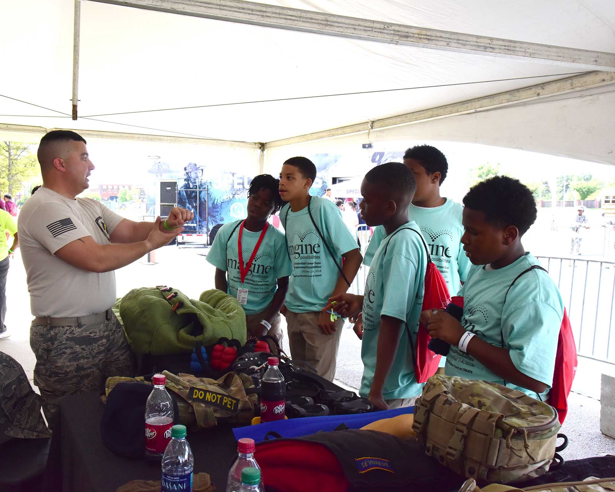 Senior Airman Logan Marini, 14th Security Forces Squadron, talks to students about military working dogs Oct. 2, 2018, during the Imagine the Possibilities Career Expo at the BancorpSouth Arena in Tupelo, Mississippi. MWD demonstrations were given several times throughout the three–day expo and handlers answered any questions from students and volunteers. (U.S. Air Force photo by Elizabeth Owens)