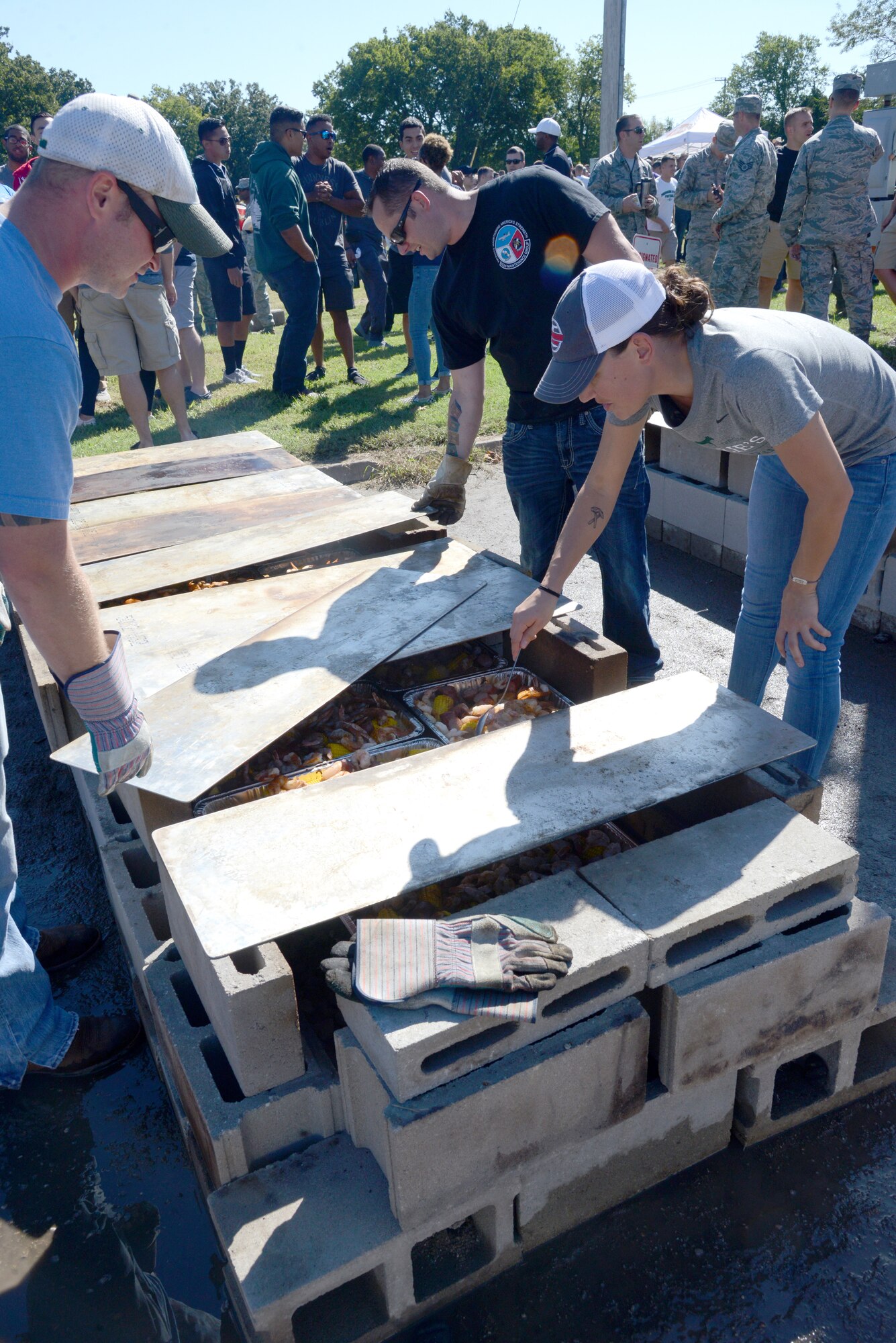 Tech. Sgts. Noah Jobe and Joey Shade, both with the 552nd Aircraft Maintenance Squadron, along with Capt. Rebecca Wynn, 552nd Operations Support Squadron, check the numerous trays of food to feed Airmen and family members at the 552nd Air Control Wing Freedom Fest Sept. 27.