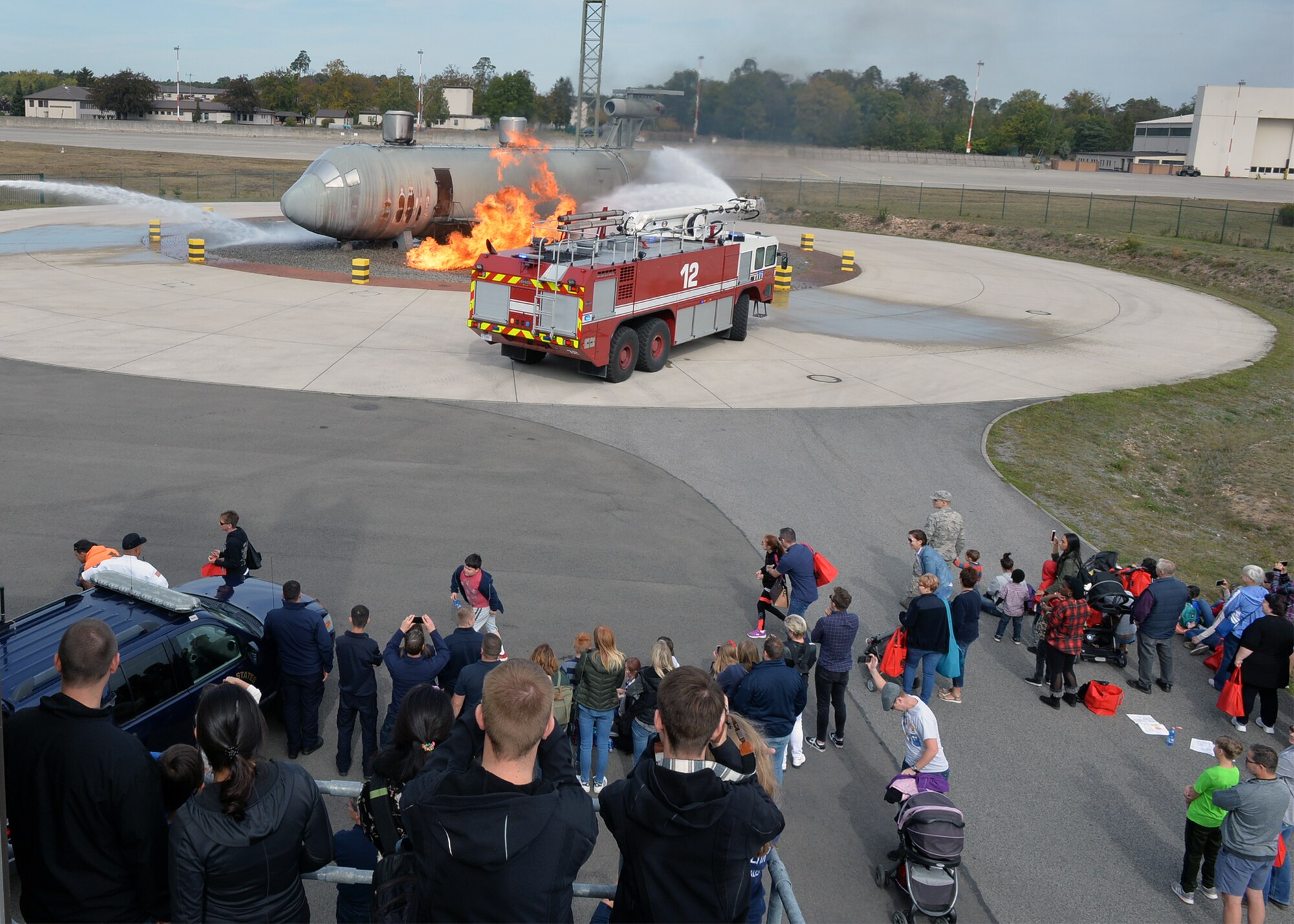 Attendees watch as firefighters assigned to the 86th Civil Engineer Squadron fight a simulated aircraft fire on Ramstein Air Base, Germany, Oct. 6, 2018. Firefighters demonstrated their capabilities for members of the Kaiserslautern Military Community as part of the fire department’s open house to kick off Fire Prevention Week. (U.S. Air Force photo by Staff Sgt. Jimmie D. Pike)