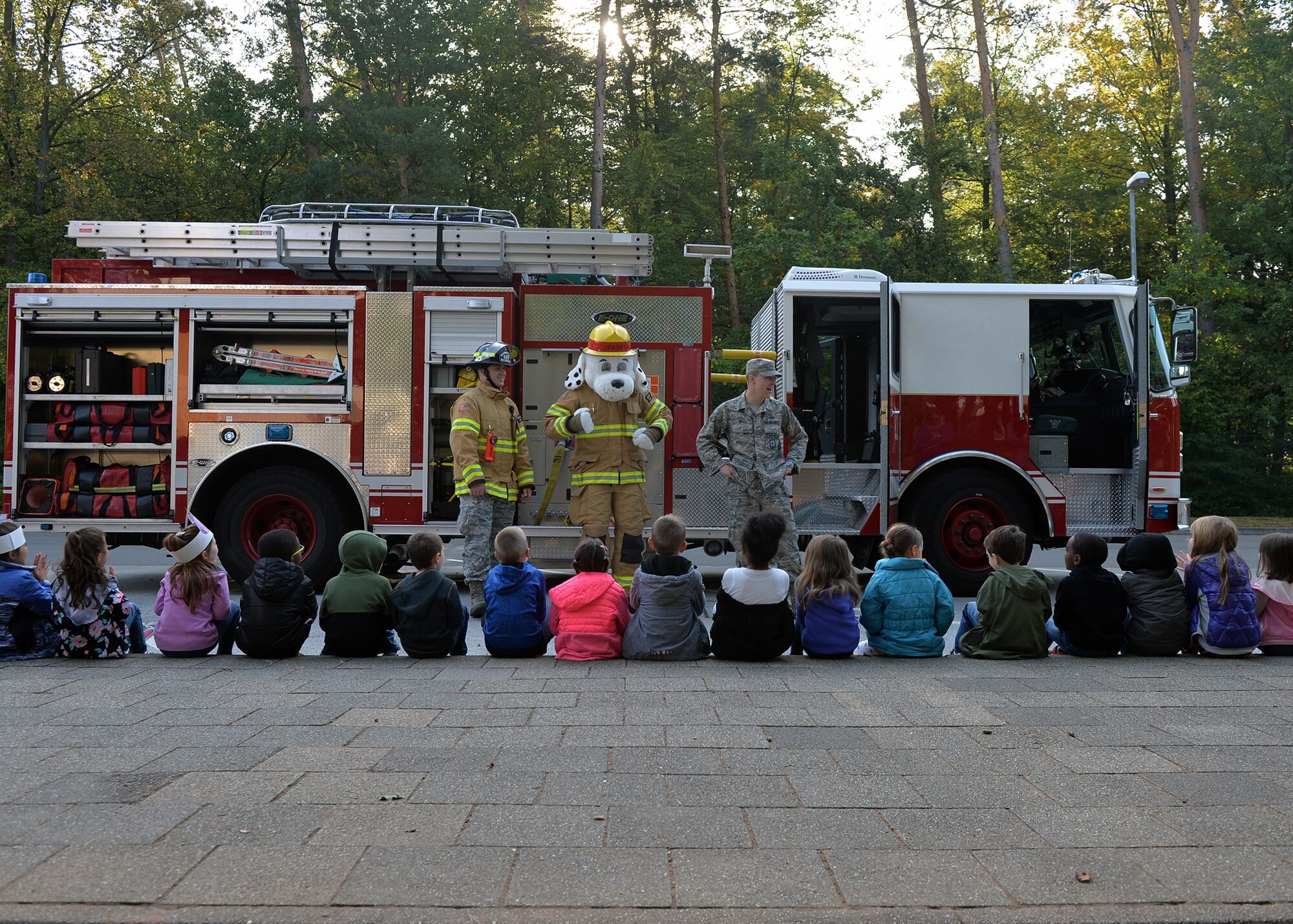 U.S. Air Force Senior Airman Dakota Ball, 86th Civil Engineer Squadron driver operator, speaks to children during a Fire Prevention Week school visit on Ramstein Air Base, Germany, Oct. 9, 2018. This year’s theme for Fire Prevention Week is, “Look, Listen, Learn. Be aware. Fire can happen anywhere.” “Look for places where a fire can happen, listen for smoke alarms, and learn two ways out of every room,” said Jason Haddock, 86th CES Fire Prevention assistance fire chief. (U.S. Air Force photo by Staff Sgt. Jimmie D. Pike)