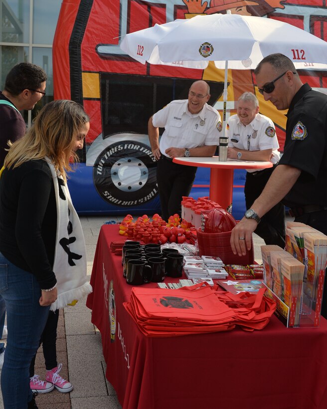 Jason Haddock, 86th Civil Engineer Squadron Fire Prevention assistant fire chief, talks to a family during Fire Prevention Week on Ramstein Air Base, Germany, Oct. 9, 2018. Throughout Fire Prevention Week, members of Kaiserslautern Military Community Fire and Emergency Services spread information about fire safety to families on base. (U.S. Air Force photo by Staff Sgt. Jimmie D. Pike)