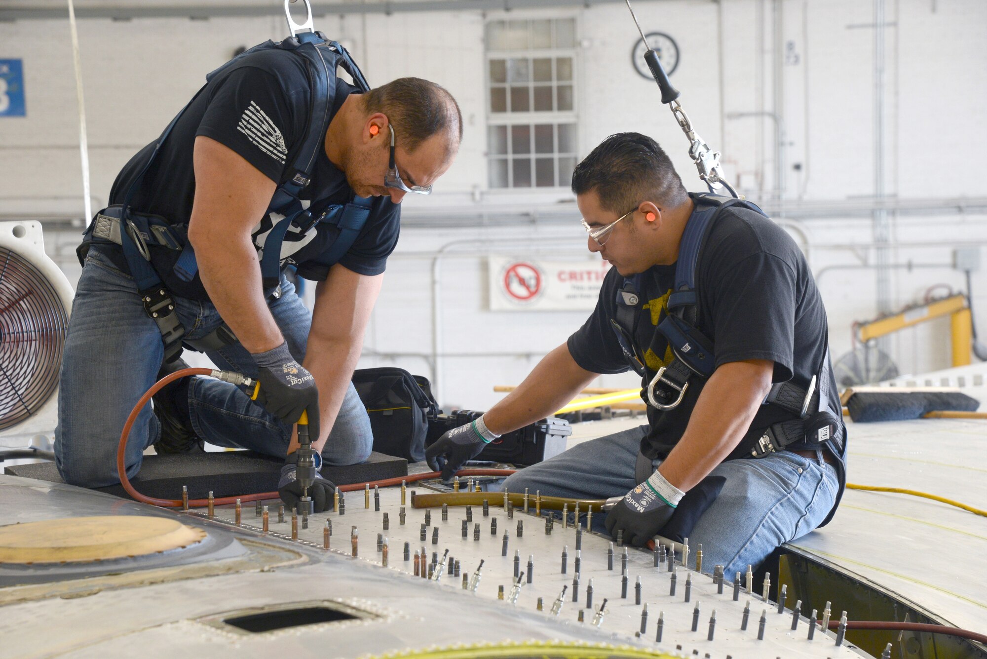 David Leon and Adrian Martinez, sheetmetal mechanics with the 565th Aircraft Maintenance Squadron, work on the stub longeron of the B-52.