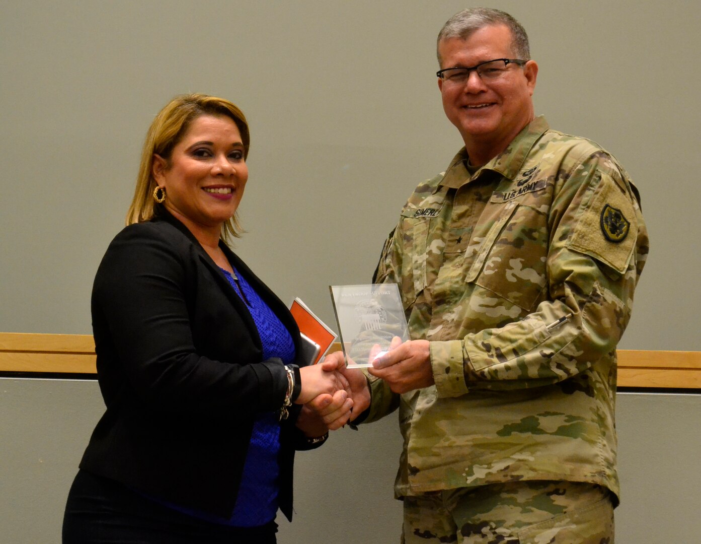 Joanna Otero-Cruz receives an award from Army Brig. Gen. Mark Simerly, DLA Troop commander, during this year’s Hispanic Heritage Month program in Philadelphia October 11, 2018.