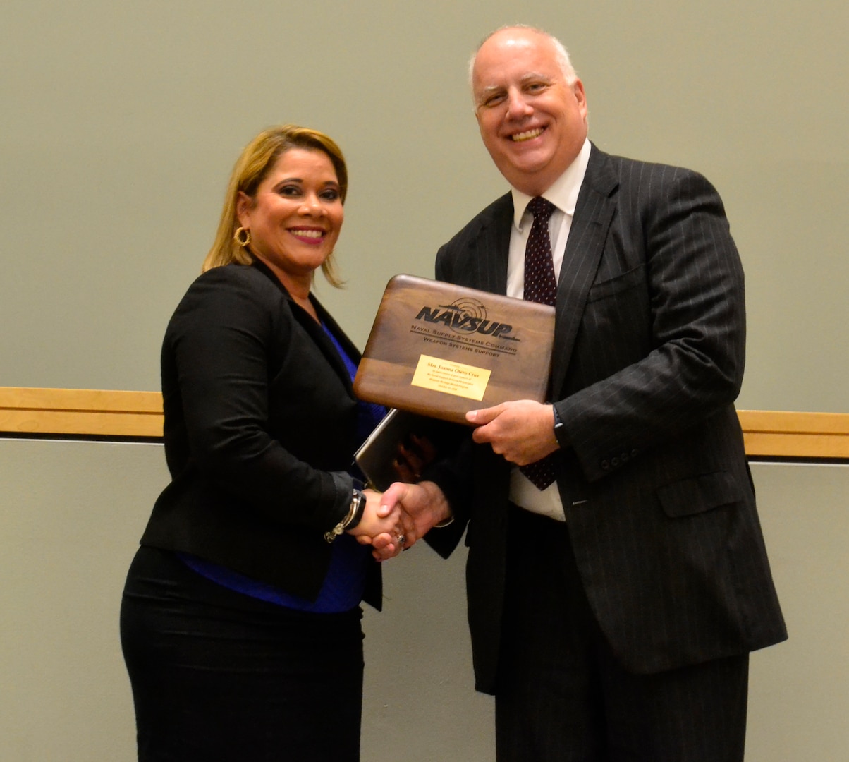 Joanna Otero-Cruz receives an award from Kurt Wendelken, NAVSUP-WSS acting vice-commander, during this year’s Hispanic Heritage Month program in Philadelphia October 11, 2018.