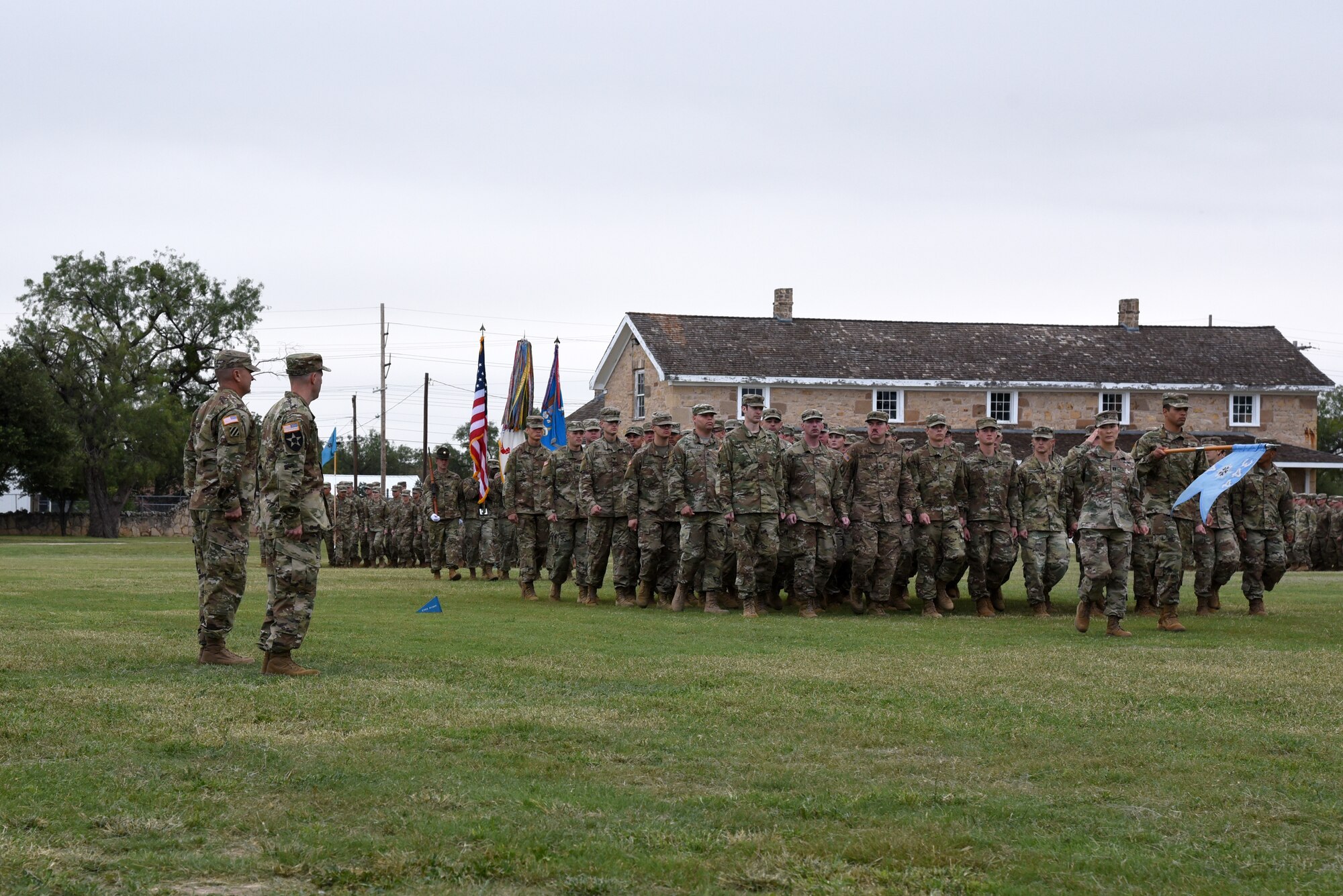 U.S. Army Col. Scott Fitzgerald, 111th Military Intelligence Brigade commander, and to Lt. Col. Brian Ryan, 344th Military Intelligence Battalion incoming commander, watch the pass and review during the 344th MI BN Change of Command at the Fort Concho parade field in San Angelo, Texas, Oct. 12, 2018. The pass and review was followed by the Army Song which signified the ending of the change of command ceremony. (U.S. Air Force photo by Staff Sgt. Joshua Edwards/Released)