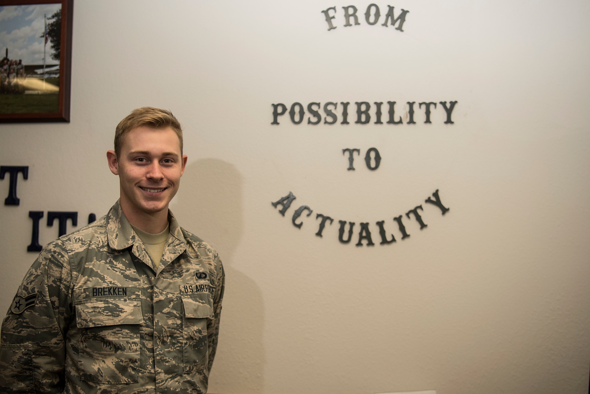 Airman 1st Class Jonathan Brekken, 628th Contracting Squadron contract specialist, stands beside his squadron’s motto Oct. 9, 2018, at Joint Base Charleston.