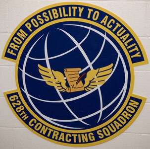 The 628th Contracting Squadron emblem is posted on the wall in the squadron.