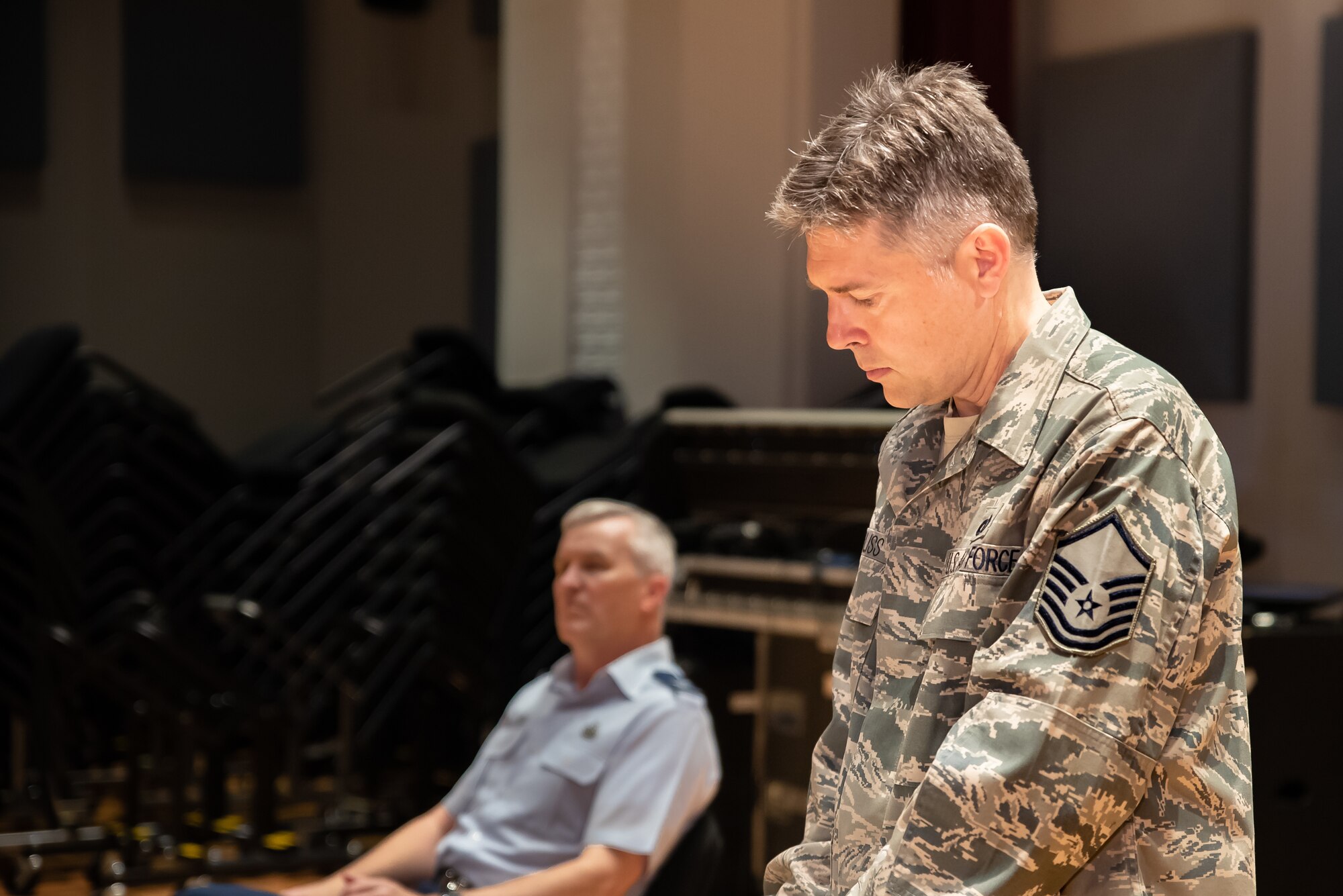 Staff Arranger Master Sgt. John Bliss overlooks a score to one of his arrangements during a rehearsal for the Fall 2019 tour