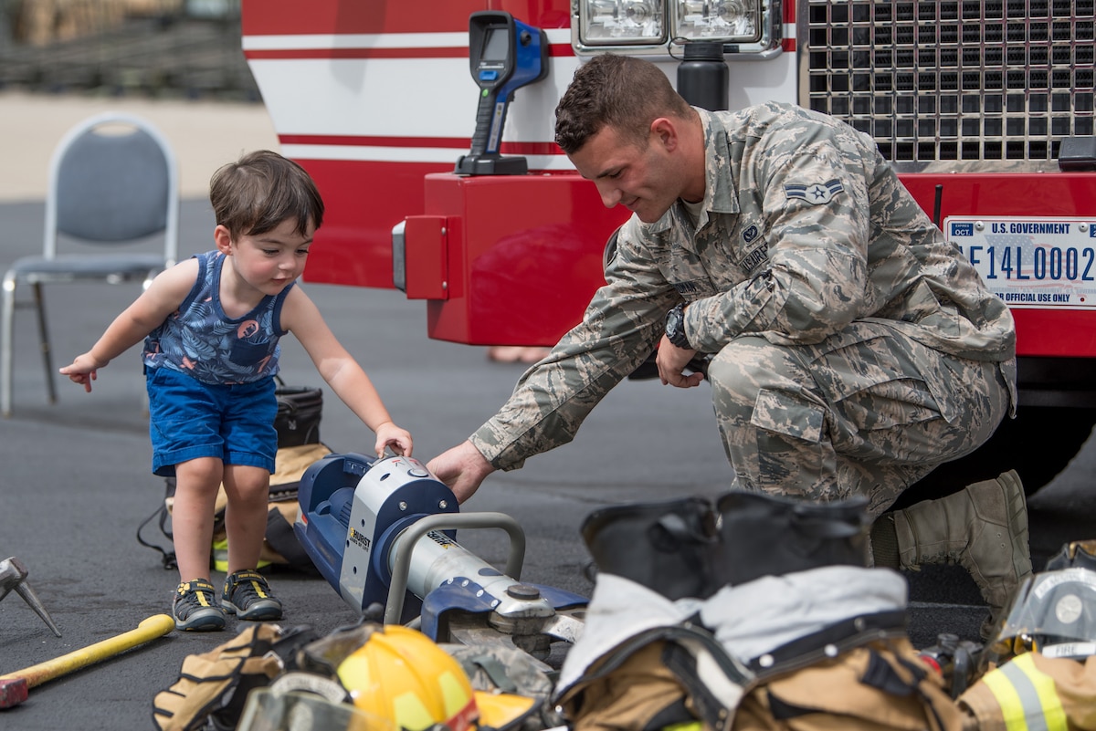 Airman 1st Class Casey Erdman, a firefighter in the 123rd Civil Engineer Squadron, demonstrates the use of hydraulic rescue tools to Ronan Daniels, son of the Kentucky Air National Guard’s Benjamin Daniels, during the 123rd Airlift Wing’s Family Day at the Kentucky Air National Guard Base in Louisville, Ky., Sept. 16, 2018. The event, which was sponsored by the Airman and Family Readiness Office and the Key Volunteer Group, featured a car show, a static-display C-130 Hercules aircraft and several other activities. (U.S. Air National Guard Photo by Staff Sgt. Joshua Horton)