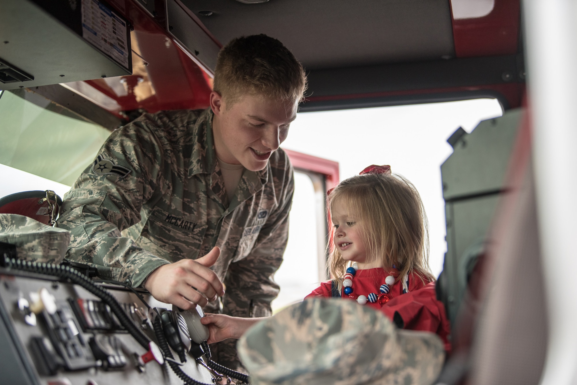 Airman 1st Class Benjamin McCarty, a firefighter assigned to the 123rd Civil Engineer Squadron, shows the unit’s fire truck to Ruby Johnson, daughter of the Kentucky Air National Guard’s Christopher Johnson, during Family Day at the Kentucky Air National Guard Base in Louisville, Ky., Sept. 16, 2018. The event, which was sponsored by the Airman and Family Readiness Office and the Key Volunteer Group, featured a car show, a static-display C-130 Hercules aircraft and several other activities. (U.S. Air National Guard photo by Master Sgt. Phil Speck)