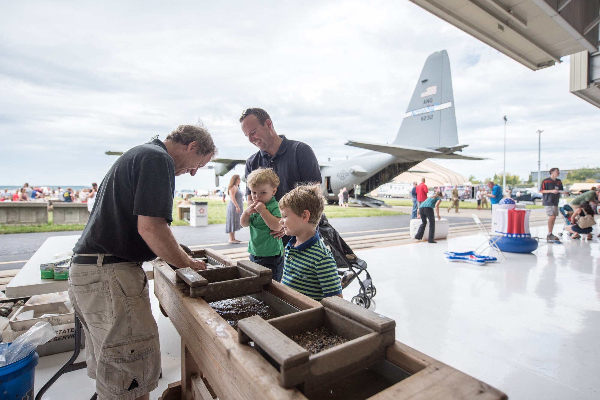Lt. Col. Jason Schmidt (right), a pilot assigned to the 165th Airlift Squadron, and his sons participate in a rock-sifting demonstration during Family Day at the Kentucky Air National Guard Base in Louisville, Ky., Sept. 16, 2018. The event, which was sponsored by the Airman and Family Readiness Office and the Key Volunteer Group, featured a car show, a static-display C-130 Hercules aircraft and several other activities. (U.S. Air National Guard photo by Master Sgt. Phil Speck)