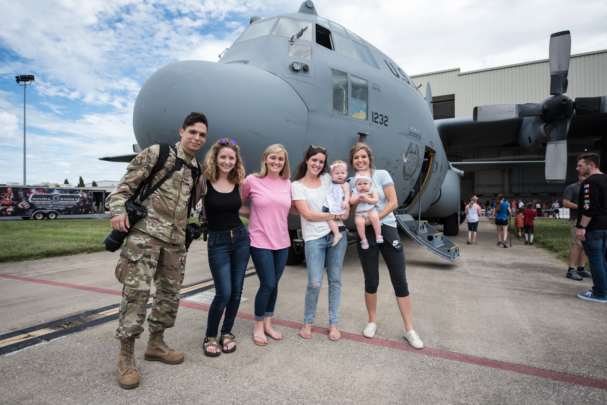 Family and friends pose in front of a 123rd Airlift Wing C-130 Hercules aircraft during Family Day at the Kentucky Air National Guard Base in Louisville, Ky., Sept. 16, 2018. The event, which drew a crowd of more than 1,000 people, featured lunch, games, a car show and numerous other activities. (U.S. Air National Guard photo by Master Sgt. Phil Speck)