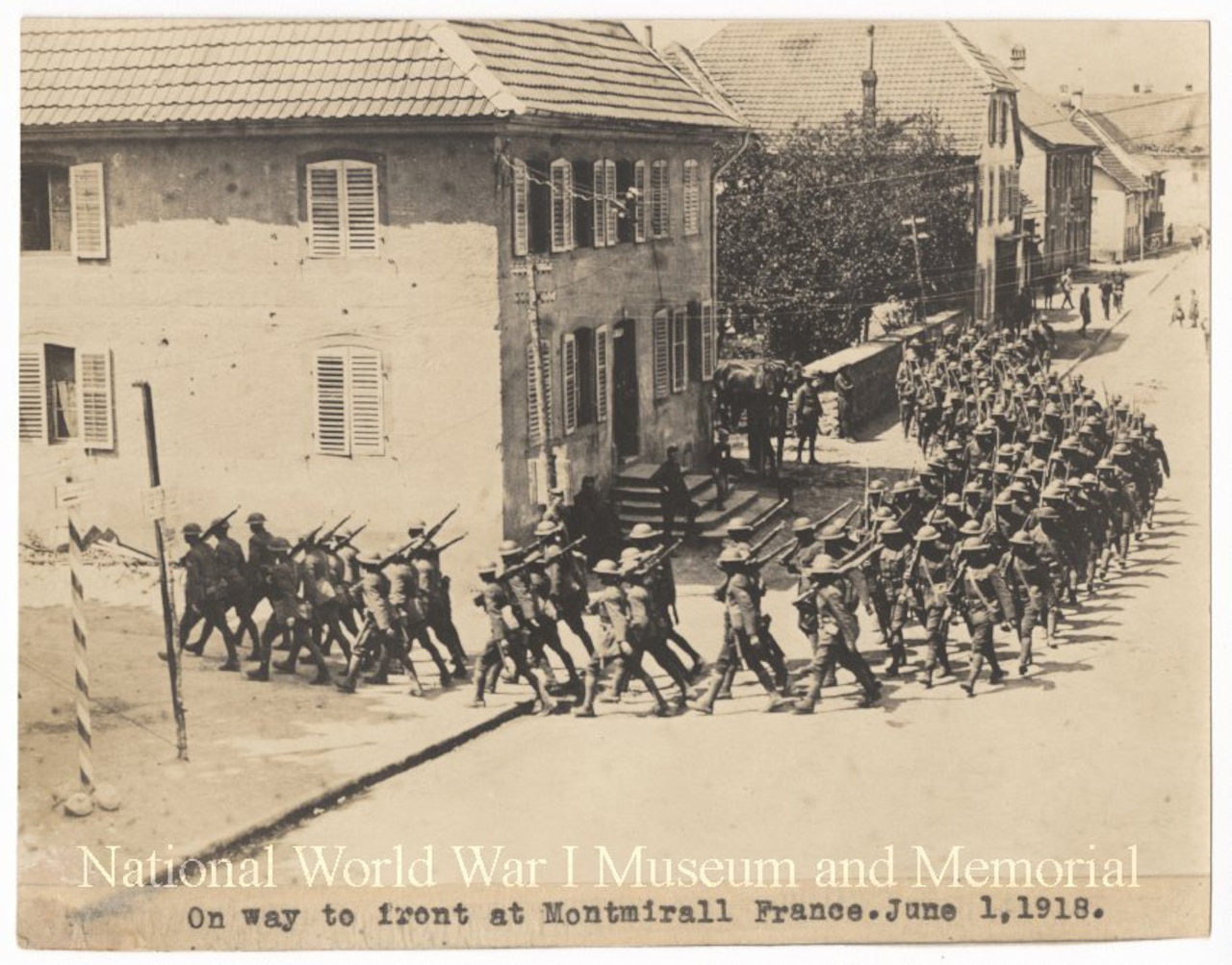 A group of American troops march through a town in World War l.