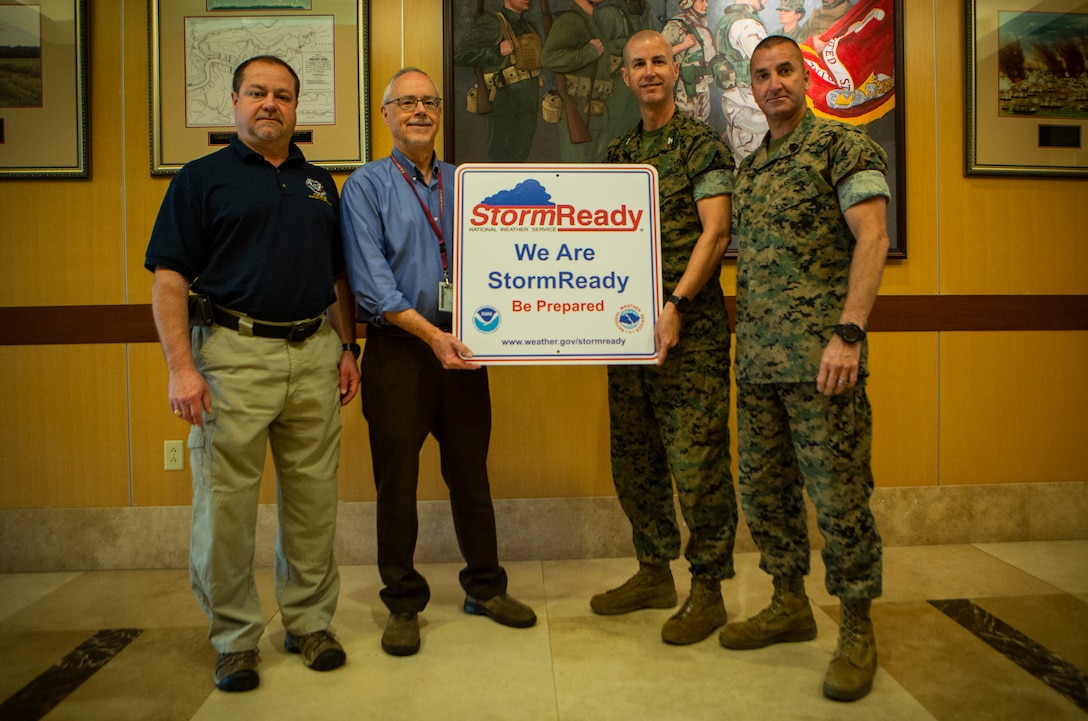 Mr. Eric Pickering (left), emergency manager for Marine Forces Reserve, Mr. Frank Revitte (left center), warning coordination meteorologist for the National Weather Service of New Orleans, U.S. Marine Col. Torrens G. Miller (right center) commanding officer of Headquarters Battalion, and Sgt. Maj. Benny R. Benton (right), sergeant major of Headquarters Battalion, pose for a group photo after receiving the National Weather Service StormReady Installation Designation Award, Oct. 10, 2018 on the MARFORRES installation. Marine Forces Reserve is the first military installation to receive this award in the state of Louisiana.  (Marine Corps photo by Cpl. Andy Martinez/released)