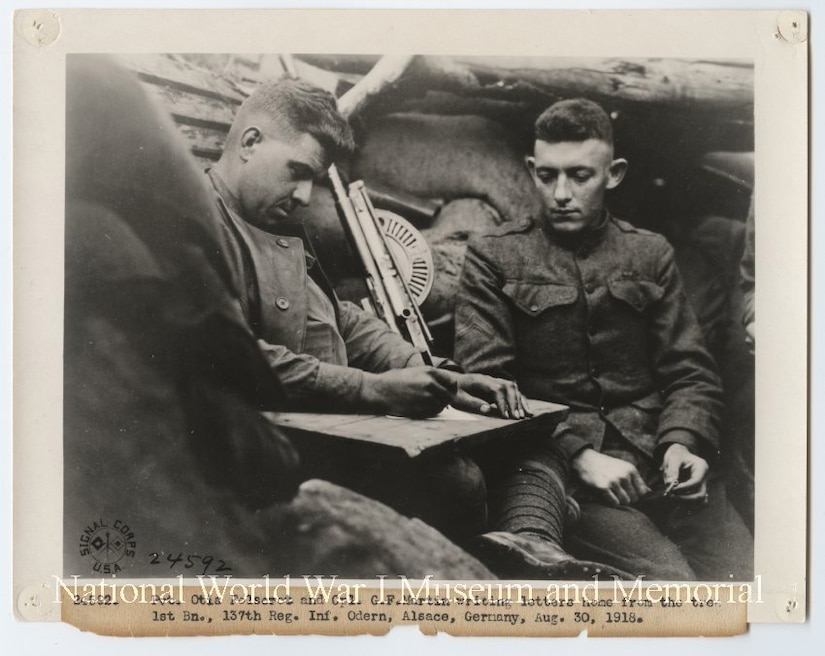 Two U.S. soldiers write letters home from a foxhole during World War l.