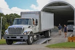 Chief Petty Officer Benjamin Allen (driver) loads a box truck onto a mockup Boeing C-17 Globemaster III while T.C. Lasker (left) and Tim Collins (right) guide him in during an air load test Oct. 9, 2018 at the C-17 Training Area at Fort Eustis, Va. This test was part of an air load plan reconfiguration and verified that two box trucks can fit side-by-side on a C-17. When directed, JTF-CS is ready to respond in 24 hours to provide command and control of 5,200 federal military forces located at more than 36 locations throughout the nation in support of civil authority response operations to save lives, prevent further injury and provide critical support to enable community recovery. (Official DoD photo by Mass Communication Specialist 3rd Class Michael Redd/released)