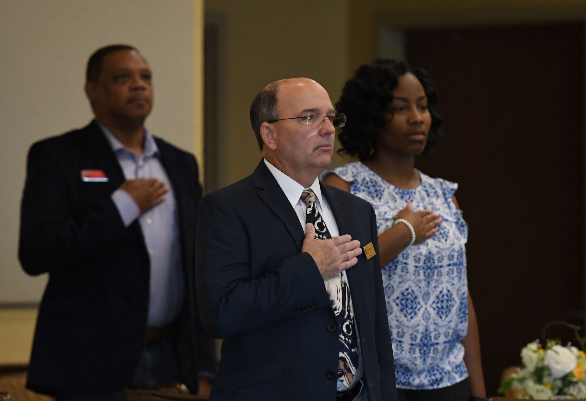 Gary Fulton, Keesler Federal Credit Union northern region director of branch operations, stands during the national anthem at the Biloxi Chamber Morning Call in the Bay Breeze Event Center at Keesler Air Force Base, Mississippi, Oct. 11, 2018. Local business and community leaders attended the event, hosted by the 81st Training Wing, to learn more about the base's mission and its Airmen. (U.S. Air Force photo by Kemberly Groue)
