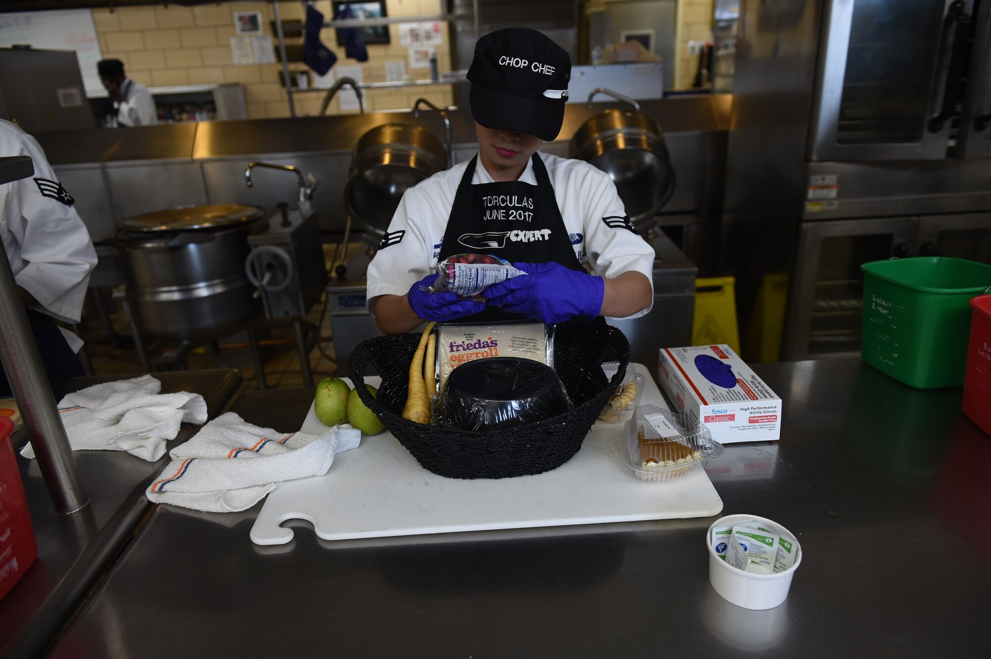 U.S. Air Force Airman 1st Class Michelle Vi Torculas, a food services specialist assigned to the 97th Force Support Squadron, looks over the ingredients she was given for the 2017 Chopped Chef Challenge, November 28, 2017, at Altus Air Force Base, Okla. The competition included five elite members of the Hangar 97 cooking staff. Torculas won the region two 2018 Arthur J. Myers Food Service Excellence Award for her hard work in events like this and in her career. (U.S. Air Force photo by Senior Airman Kirby Turbak)