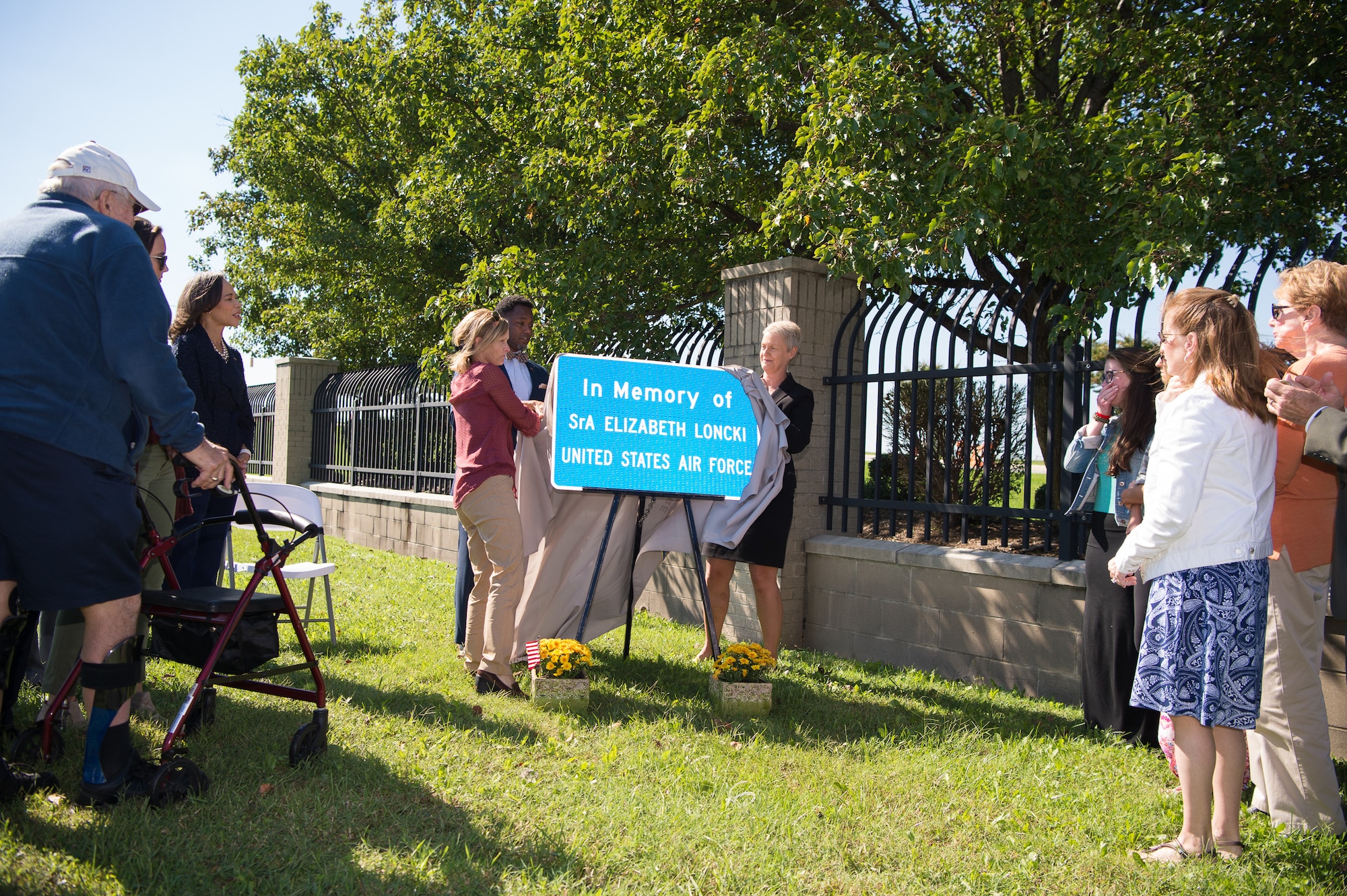 Family members and friends watch as the memorial sign is unveiled during the Senior Airman Elizabeth Loncki bridge dedication ceremony Oct. 12, 2018, at Dover Air Force Base, Del.