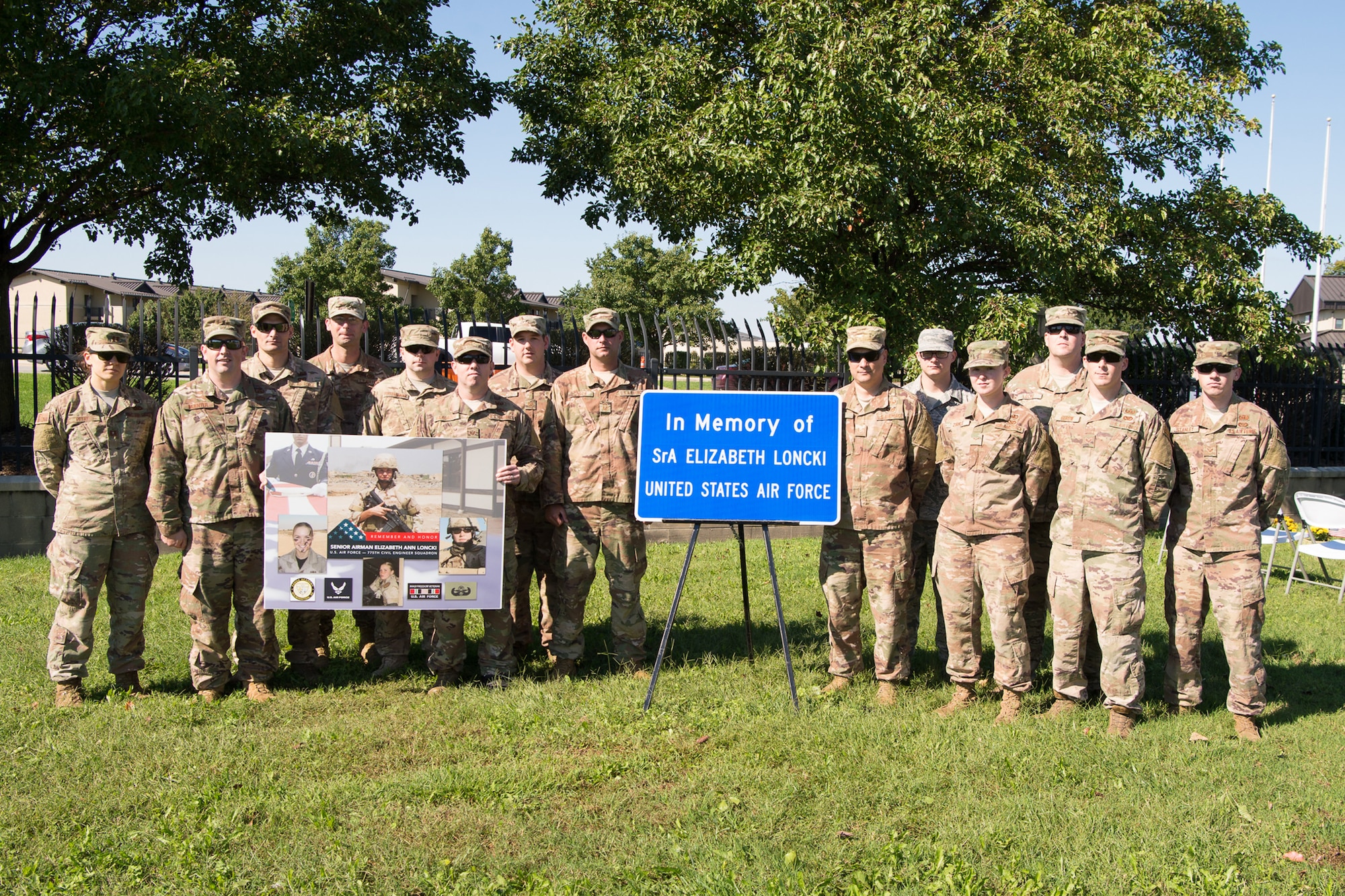 Airmen of the 436th Civil Engineer Squadron Explosive Ordnance Flight pose next to the memorial sign at the Senior Airman Elizabeth Loncki bridge dedication ceremony Oct. 12, 2018, at Dover Air Force Base, Del.