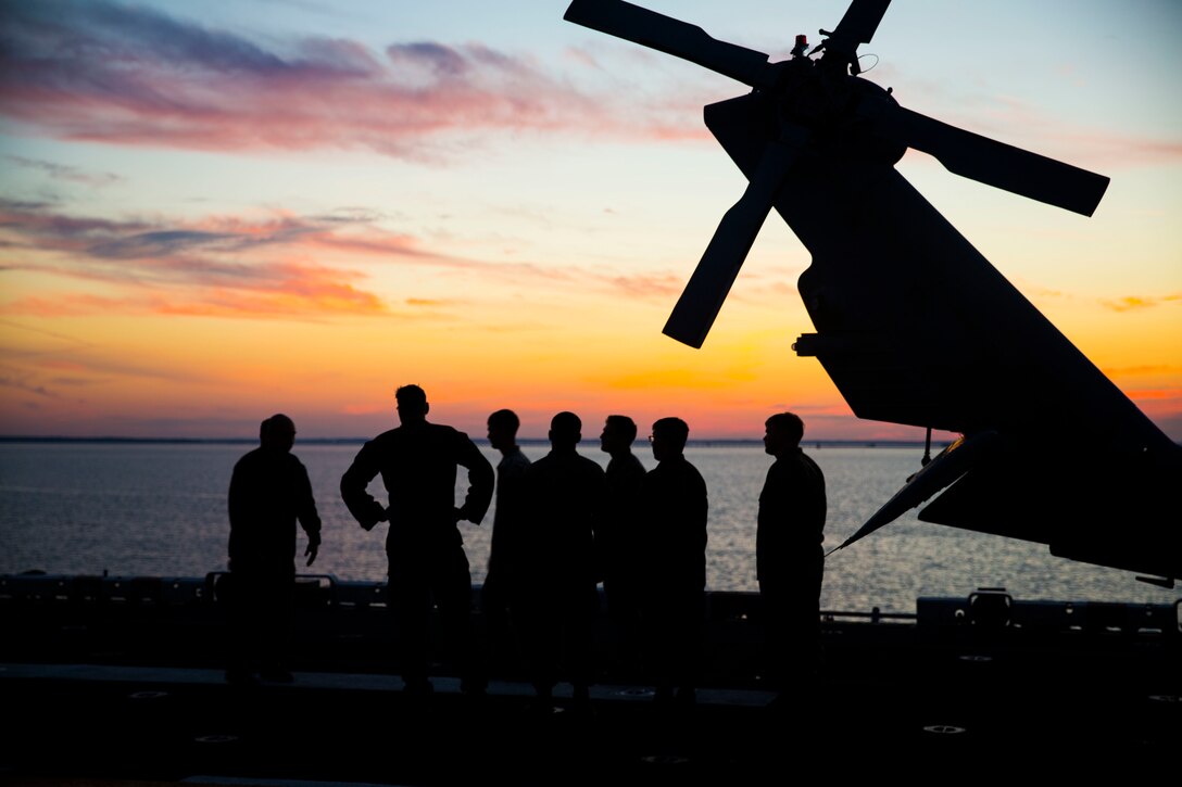 Marines and sailors with the 24th MEU watch the sunset while embarking from Naval Station Norfolk, Virginia, Oct. 2 in preparation of Exercise Trident Juncture 18.