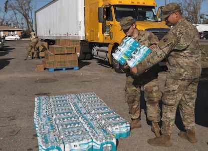 Florida National Guard Soldiers from the 53rd Infantry Brigade Combat Team, 2-124 Charlie Co., Ocala, Fla., stack water at the Rosenwald High School point of distribution to give to local citizens during Hurricane Michael disaster relief, Panama City, Fla., Oct. 13, 2018.