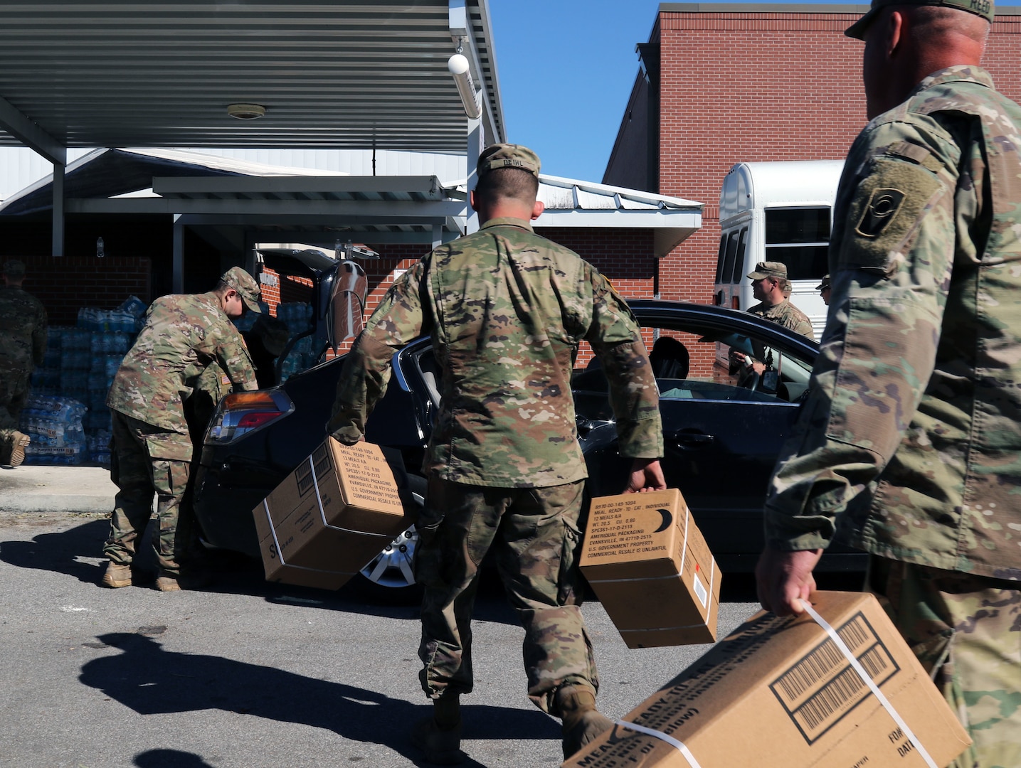 Florida National Guard Soldiers from the 53rd Infantry Brigade Combat Team, 2-124 Charlie Co., Ocala, Fla., load food in to a local citizen’s vehicle during Hurricane Michael disaster relief, Panama City, Fla., Oct. 13, 2018.  Soldiers respond in communities throughout the panhandle in conjunction with civilian emergency services.